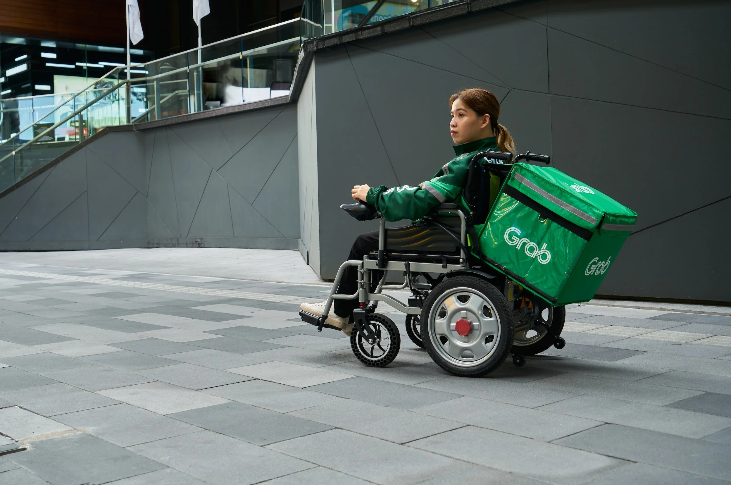 A young girl in a wheelchair delivering food