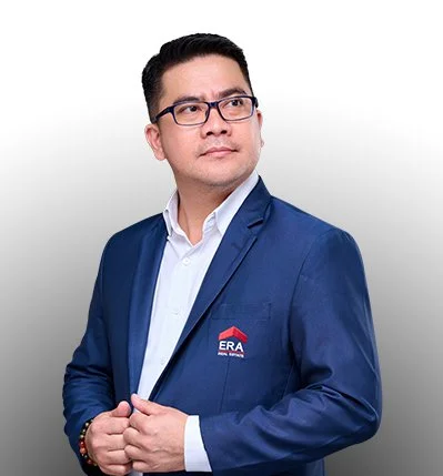 Professional man in a blue suit with glasses, wearing a white shirt and a badge with ERA logo, standing against a plain white background.