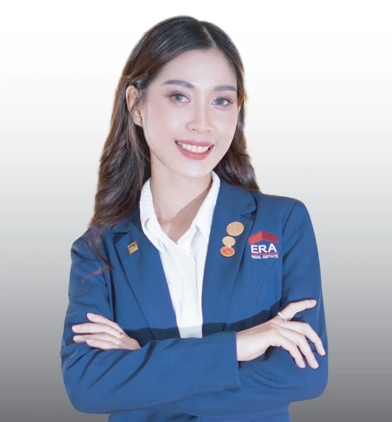 Professional woman with long hair wearing a blue blazer with ERA logo, white shirt, smiling with arms crossed against a gray gradient background.