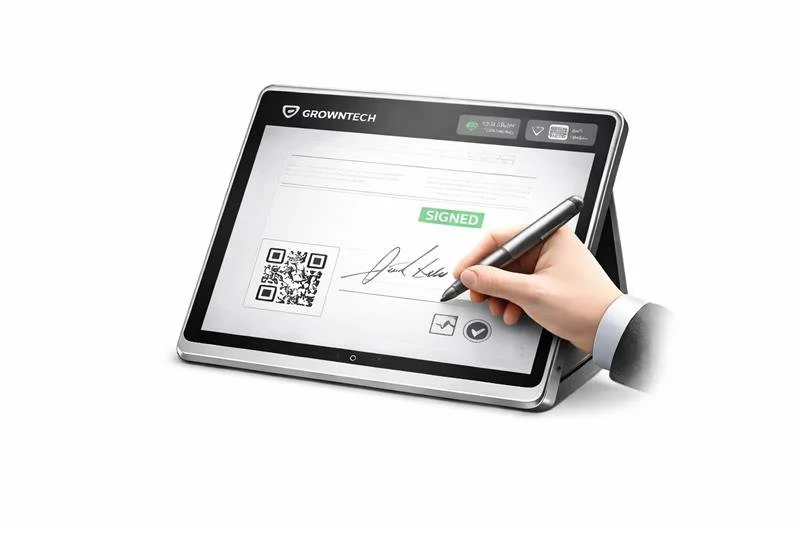 Person signing a digital document on a tablet using a stylus, with a green 'SIGNED' stamp visible on the screen.