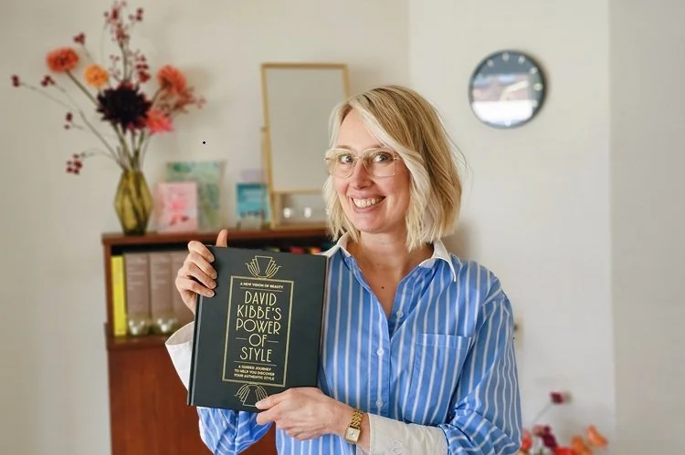 Styliste Judith van Oudheusden houdt David Kibbes boek vast voor boekenkast