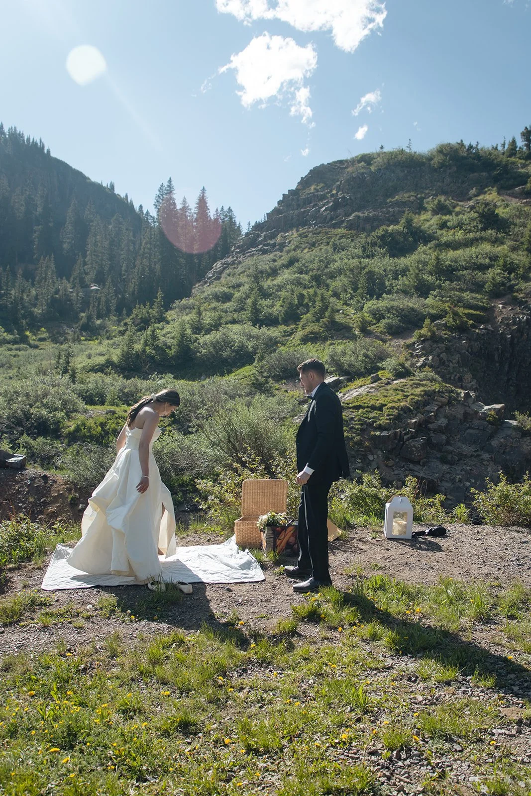 bride and groom setting up their picnic by a waterfall