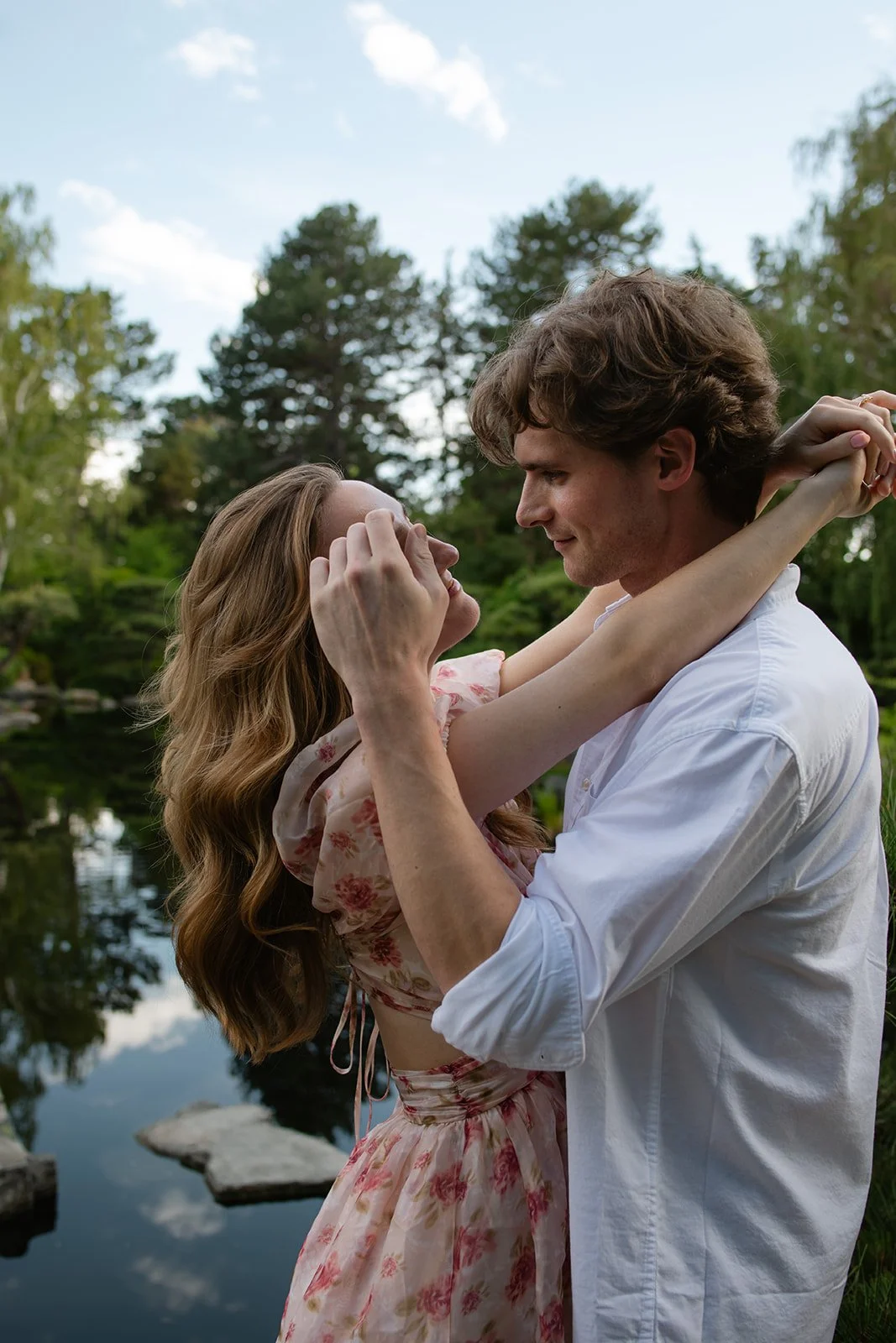 a man brushing a woman's hair out of her face and she embraces him, taken by a Denver engagement photographer
