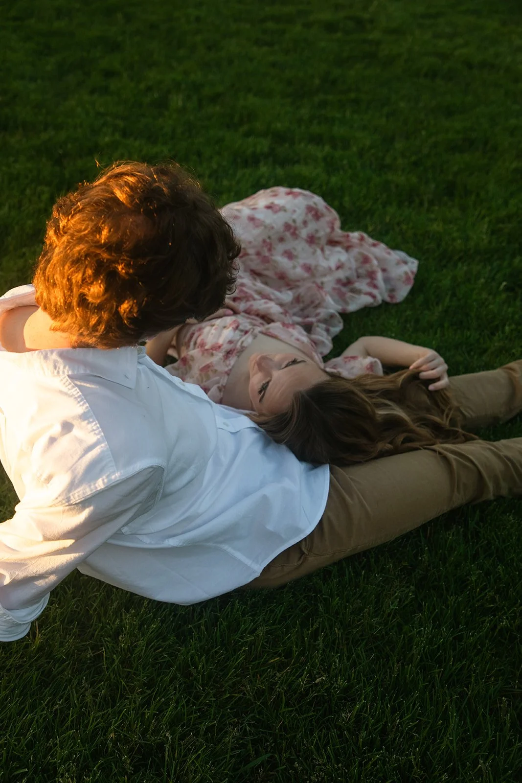 a couple sitting in the grass together during Denver engagement photos