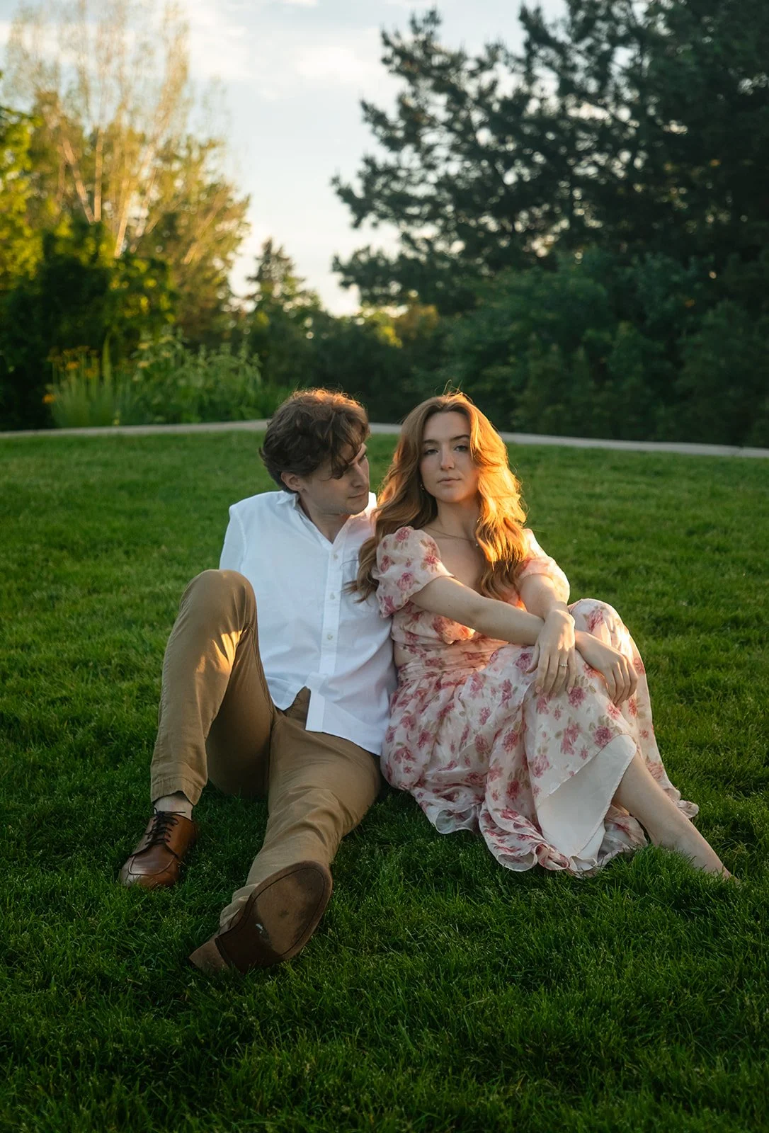a woman looking at the camera as the man next to her looks at her, taken by a Denver engagement photographer