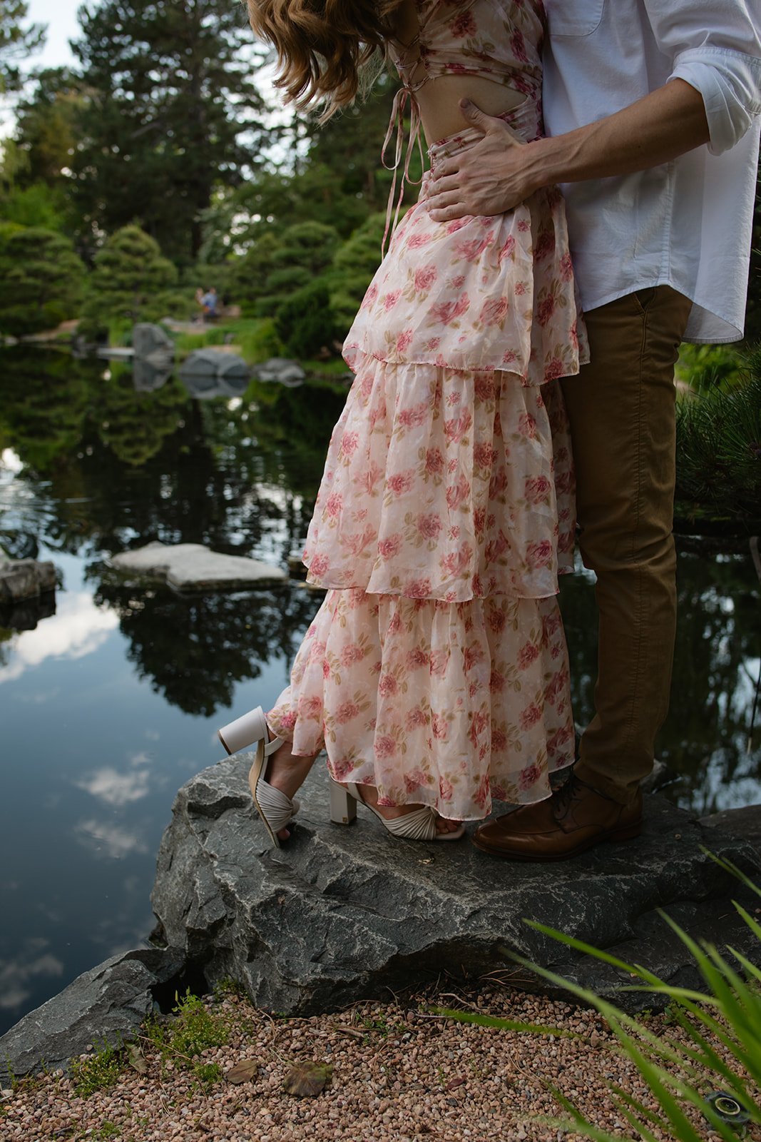 a couple embracing by the pond from the waist down, taken by a Denver engagement photographer