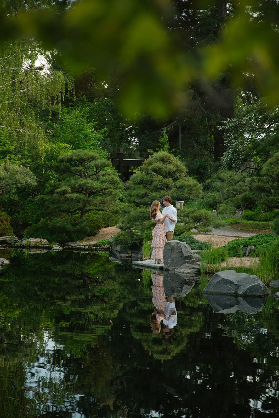 a newly engaged couple dancing by the pond, taken by a Denver engagement photographer