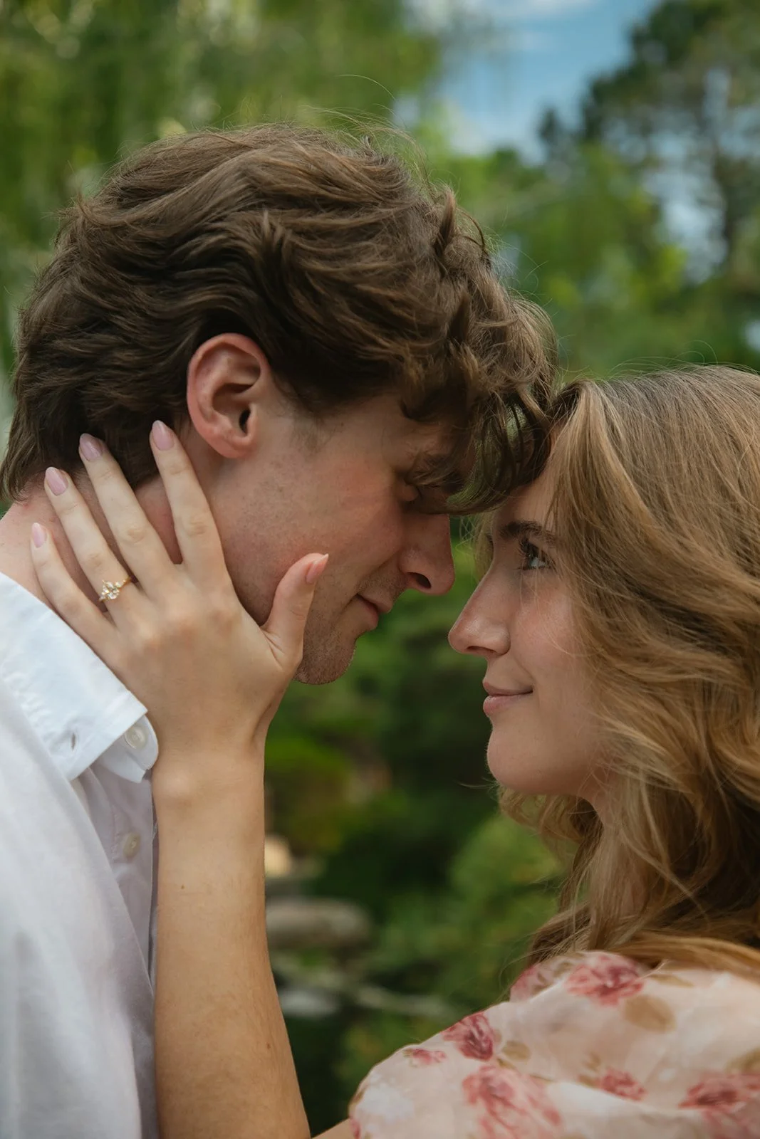 a man and woman placing their foreheads together as they look at each other 