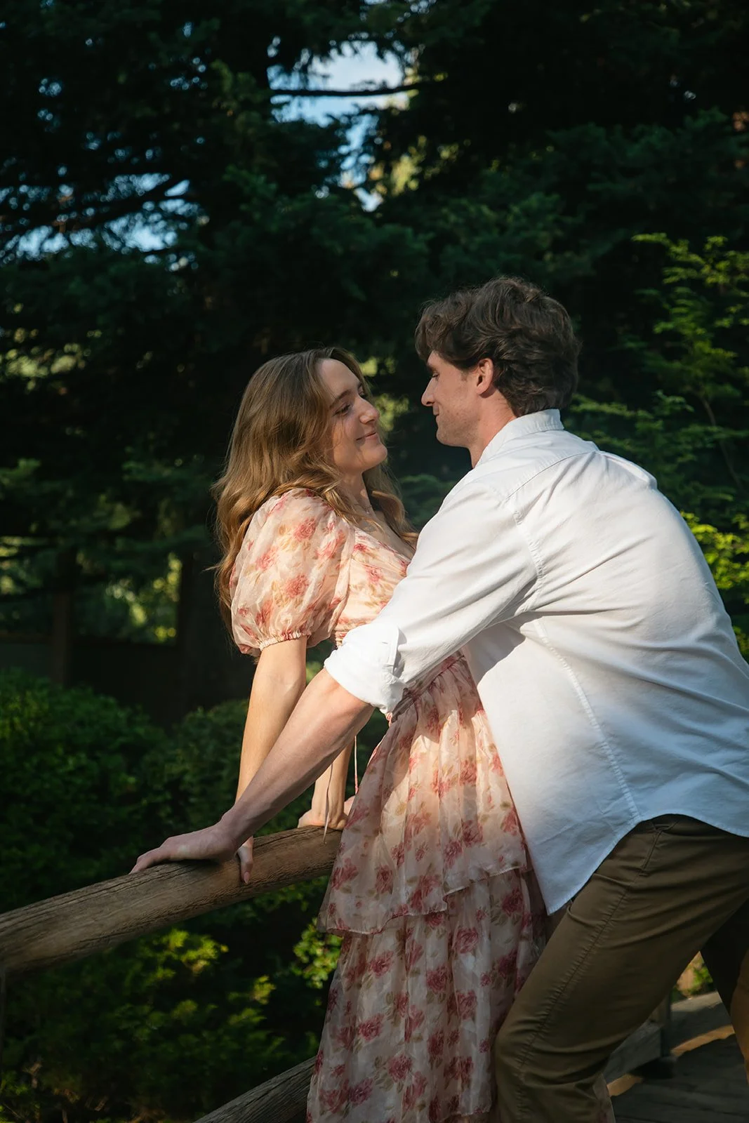 a couple leaning on a railing together during Denver engagement photos