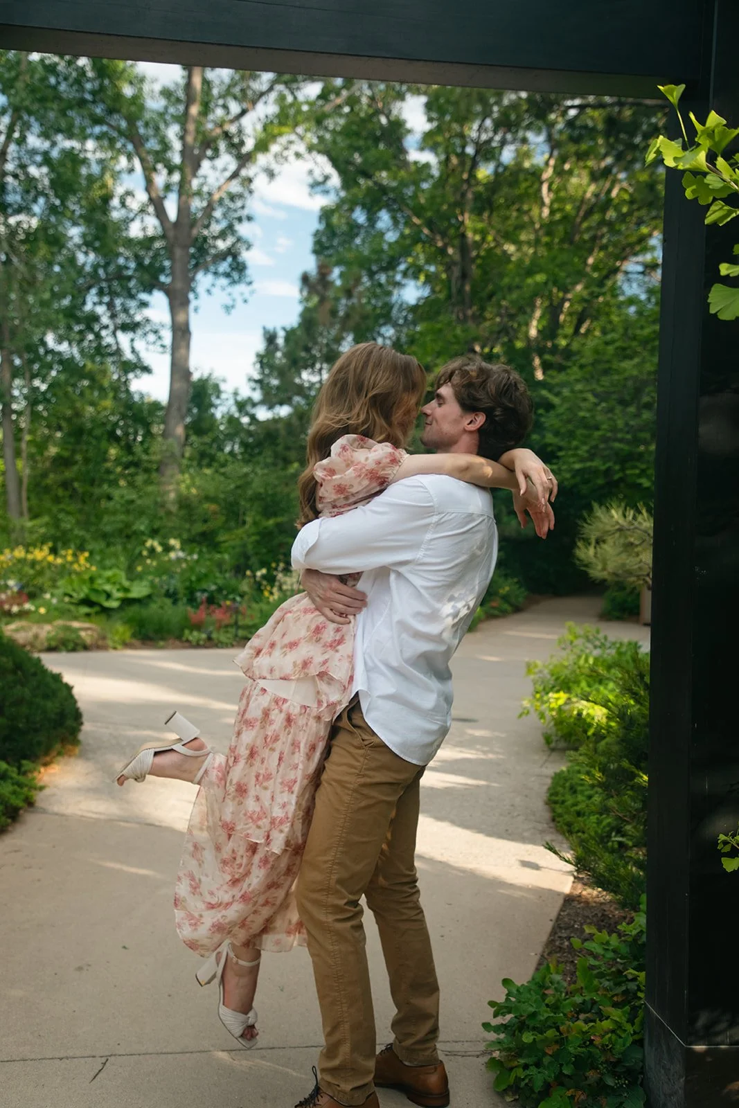 a man picking up a woman under an arch, taken by a Denver engagement photographer