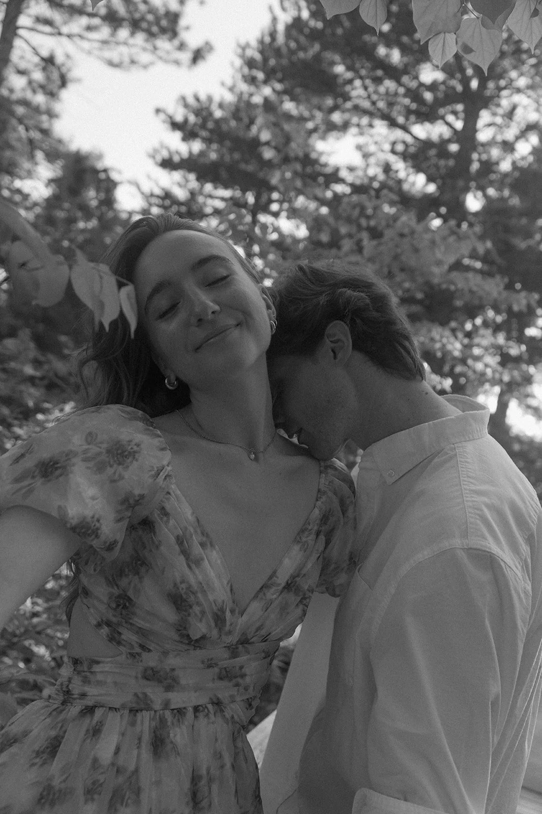 a man kissing a woman's clavicle 
