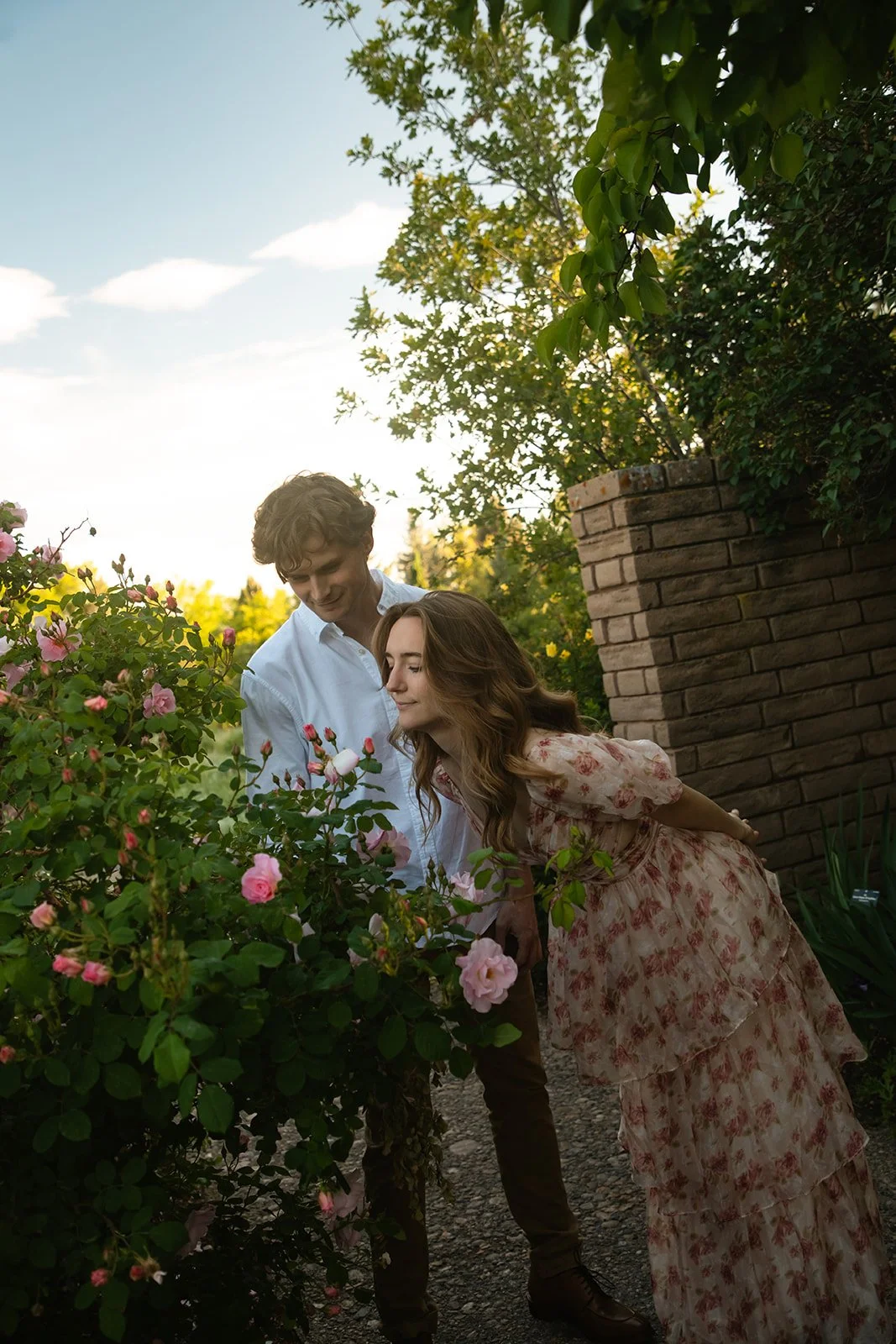 a couple smelling the roses together, taken by a Denver engagement photographer