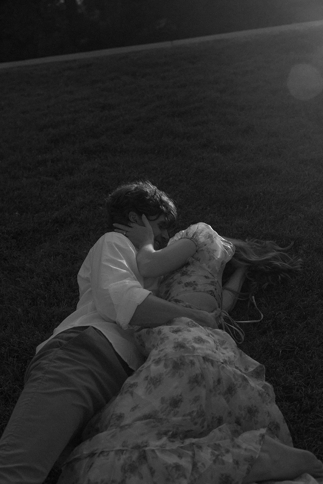 a couple rolling around in the grass together during Denver engagement photos