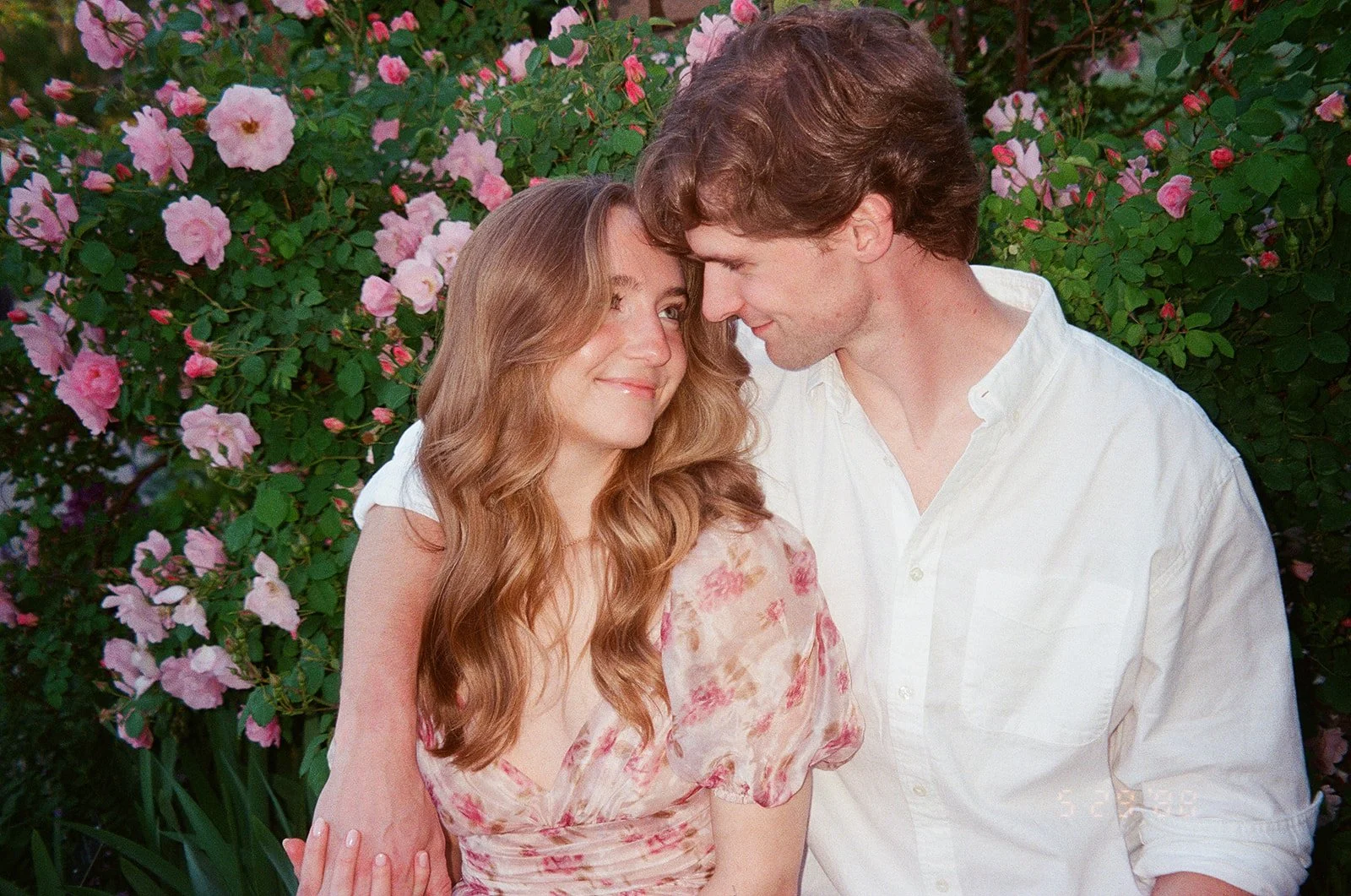a film engagment photo in front of roses