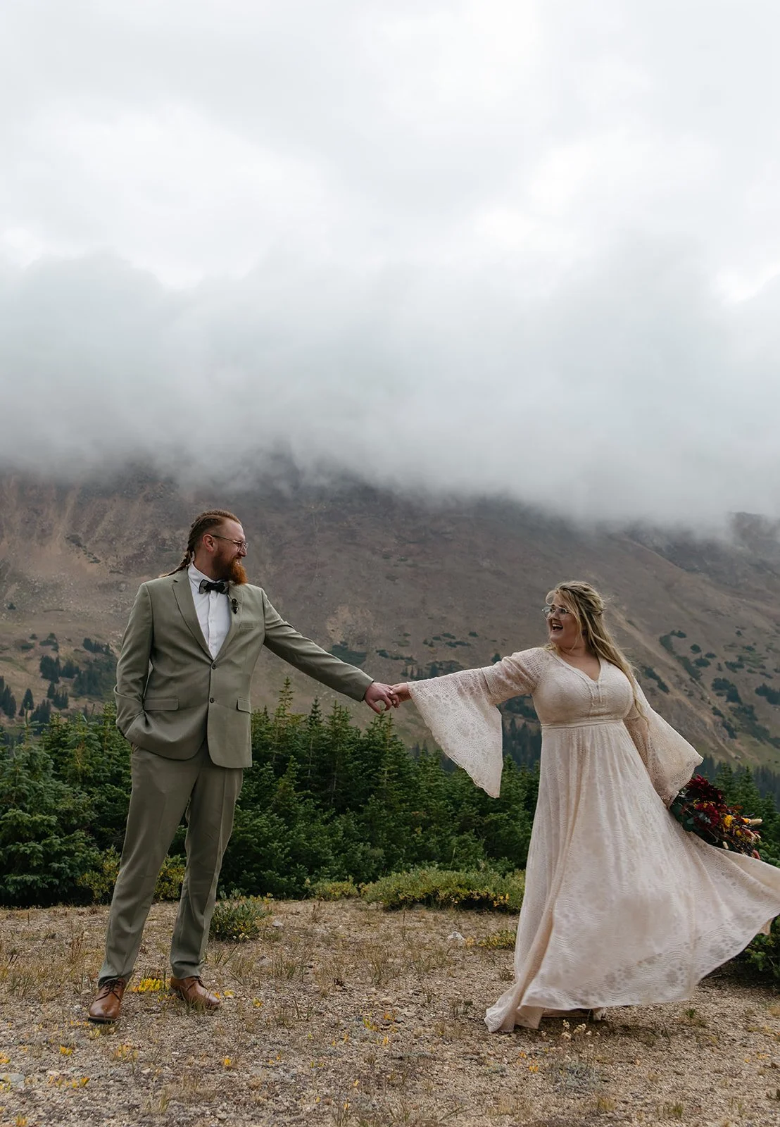 a couple dancing together with the fog and mountains behind them in Colorado