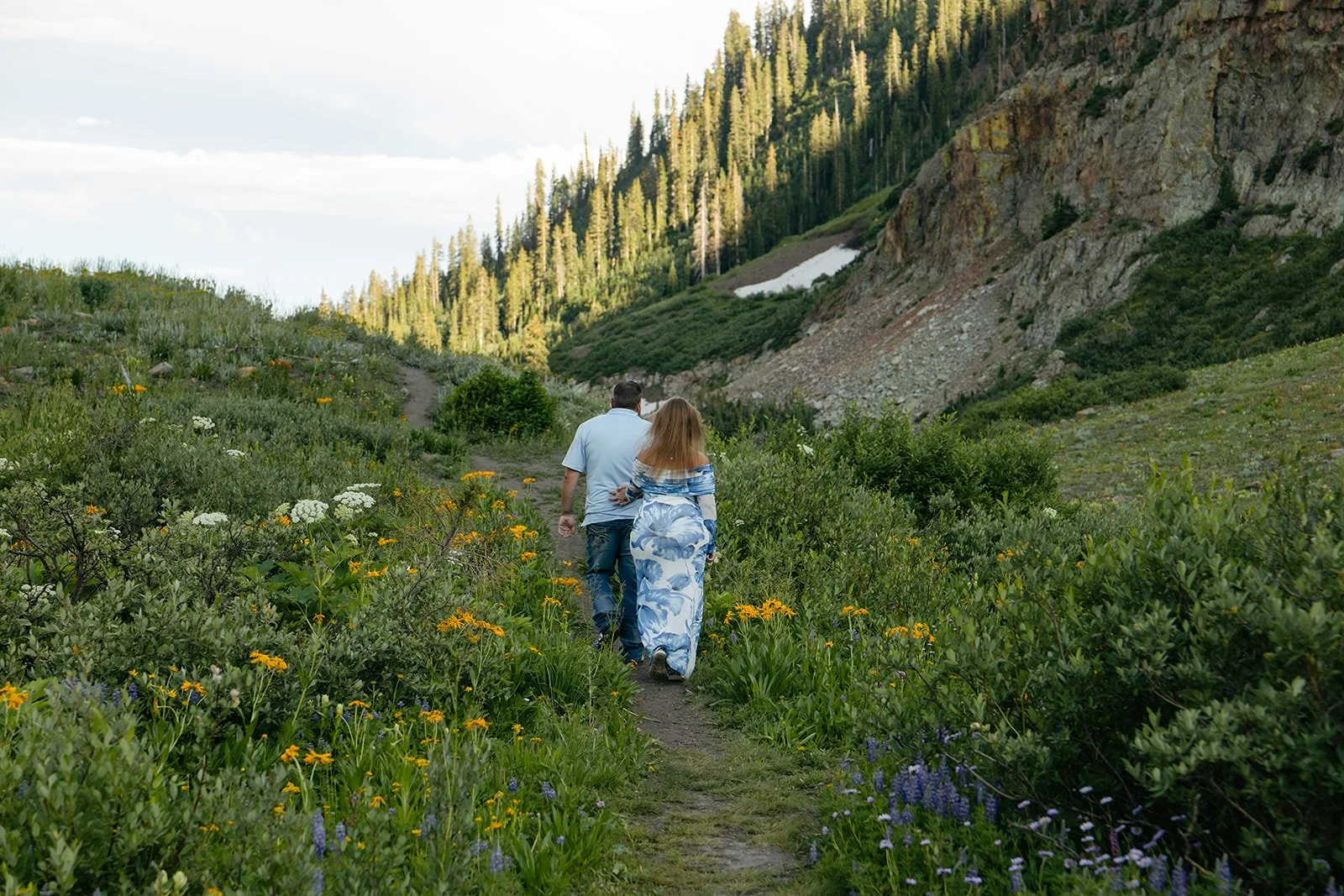 a couple walking up a mountain trail at a great Engagement Photo Location in Colorado