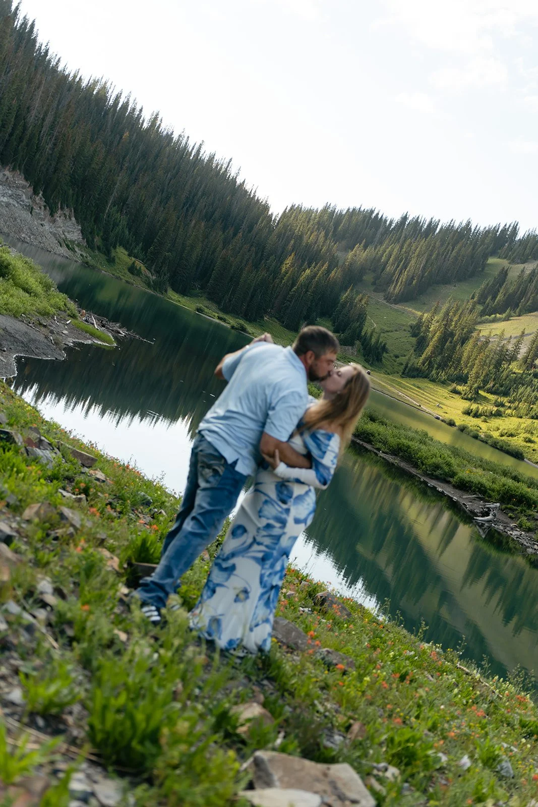 a couple kissing at a beautiful lake Engagement Photo Location in the mountains