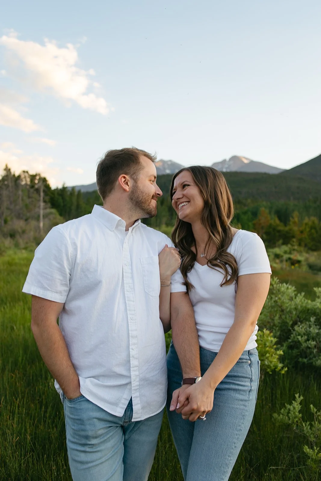 a couple holding hands and smiling at a mountain Engagement Photo Location in Colorado
