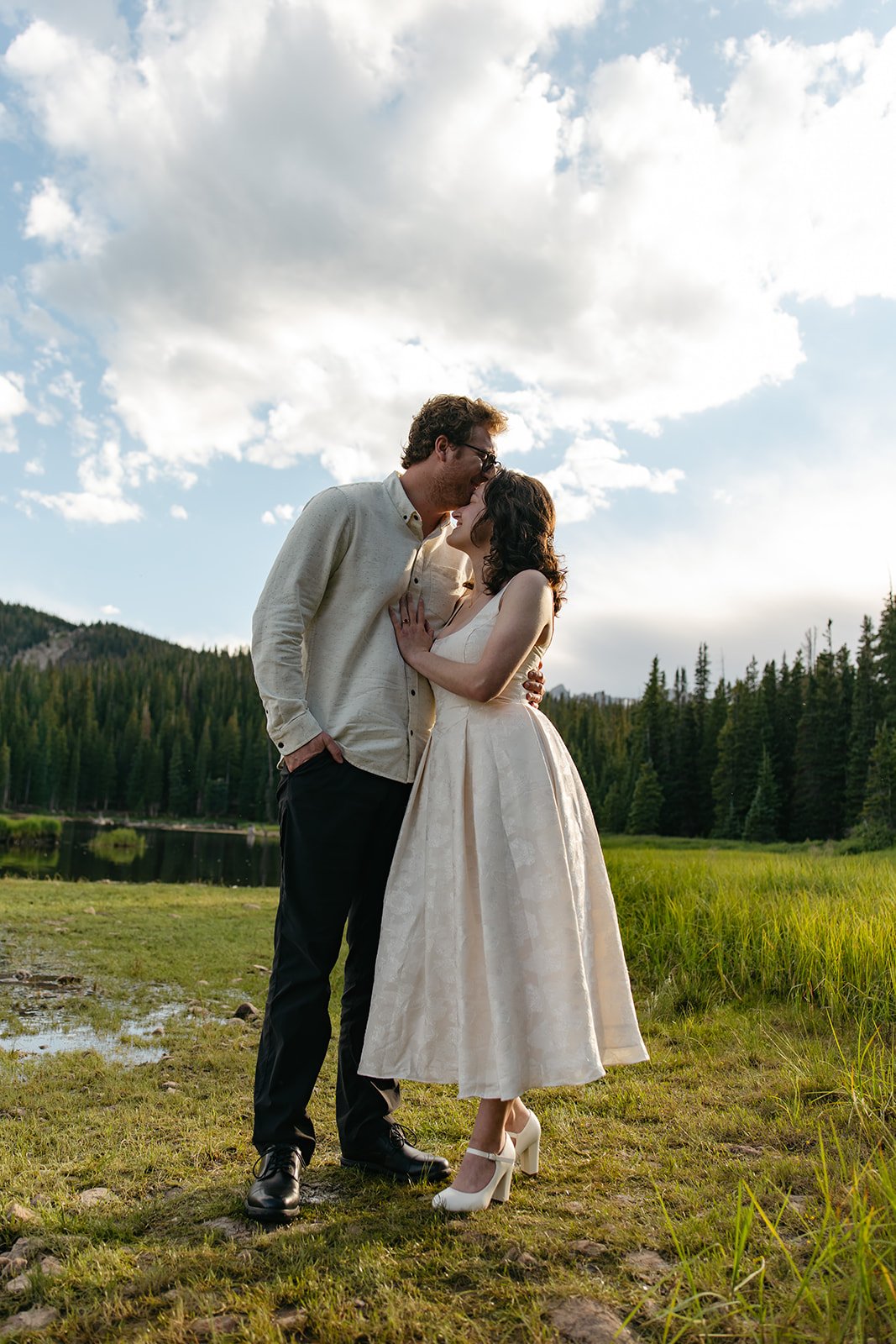 a man kissing a woman on the top of her head in a beautiful Engagement Photo Location