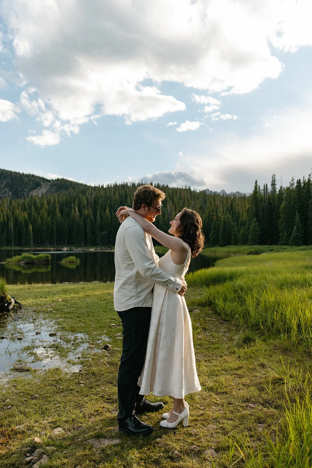 a couple holding each other with a lake in the background in CO