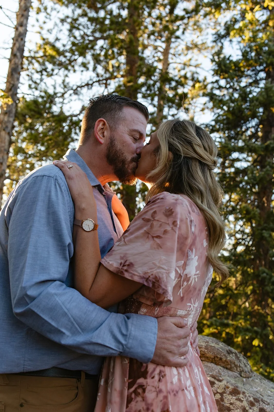 a couple kissing in the words during golden hour in Colorado