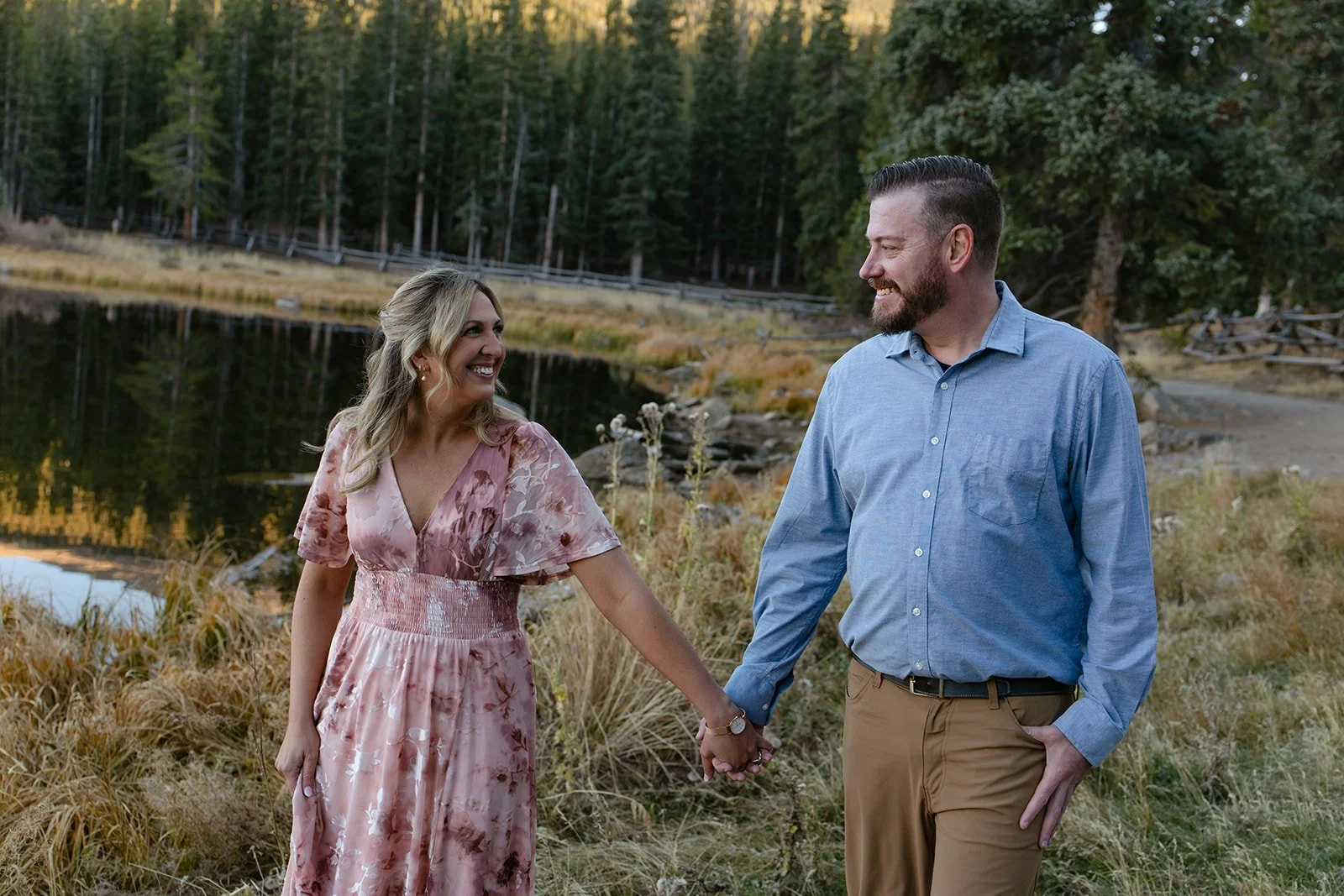 a couple smiling together by the lake at a Colorado Engagement Photo Location