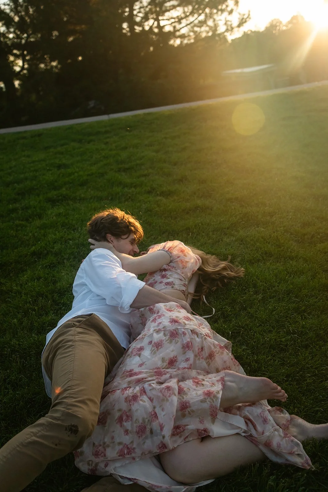 a couple laying in the grass at sunset at a favorite Engagement Photo Location in CO