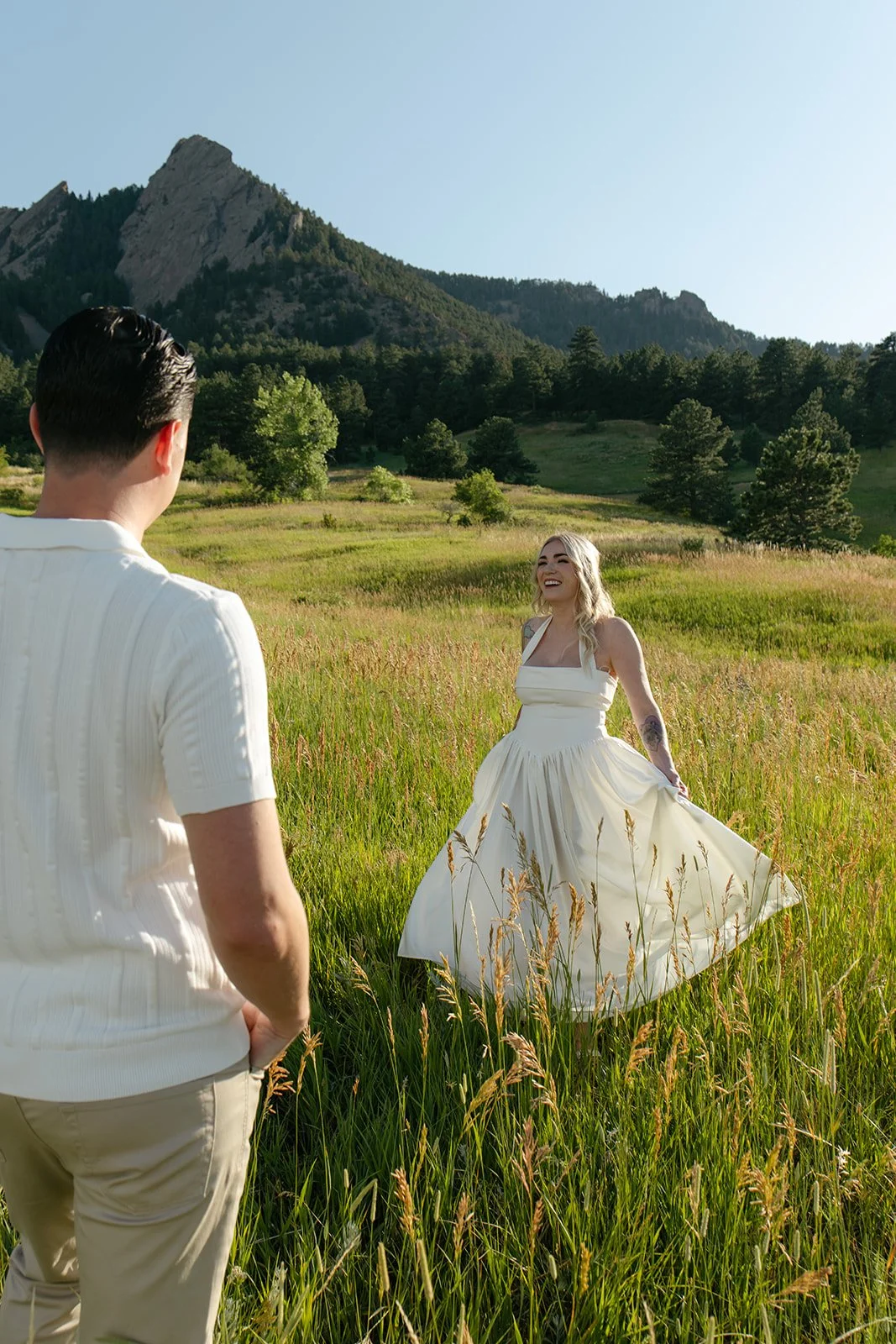 a woman dancing as a man watches her at a favorite mountain Engagement Photo Location in CO