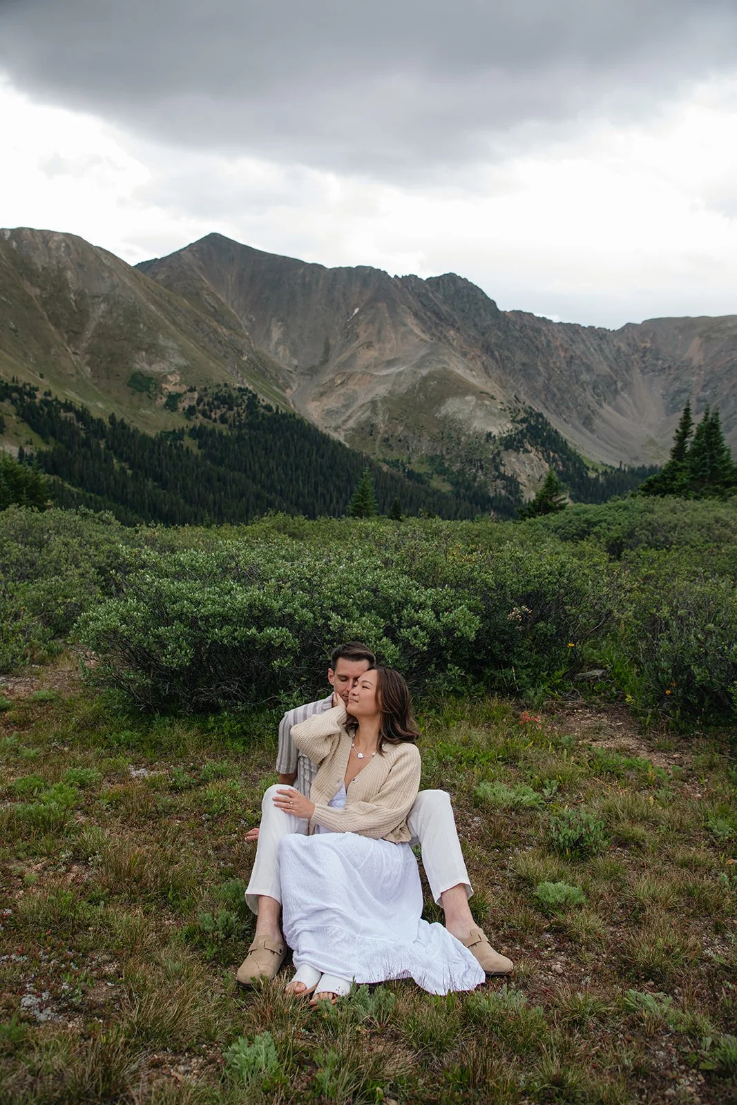 a couple sitting together at a mountain view Engagement Photo Location in Colordao