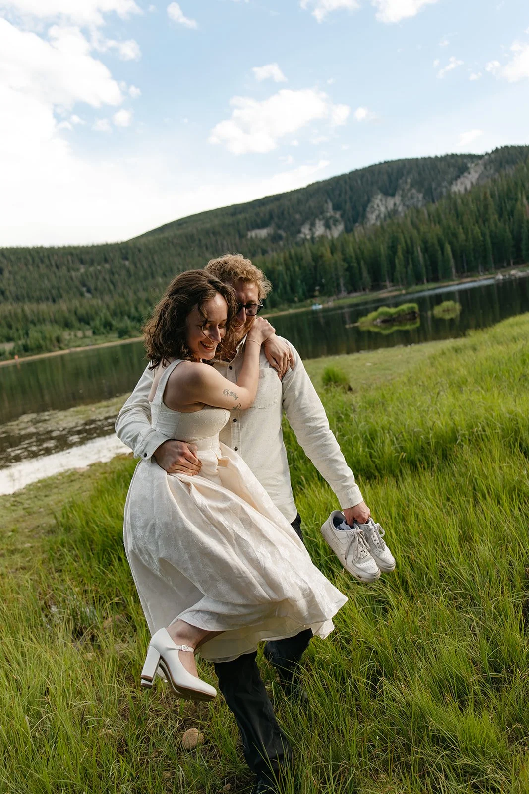 a man carrying a woman through some grass