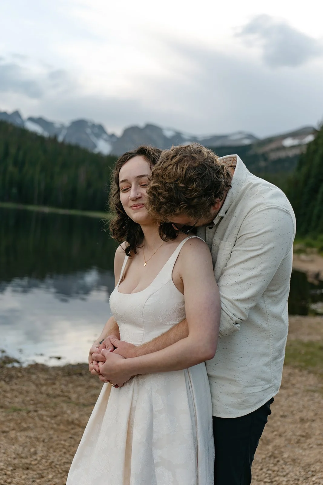 a man kissing a woman's shoulder in CO