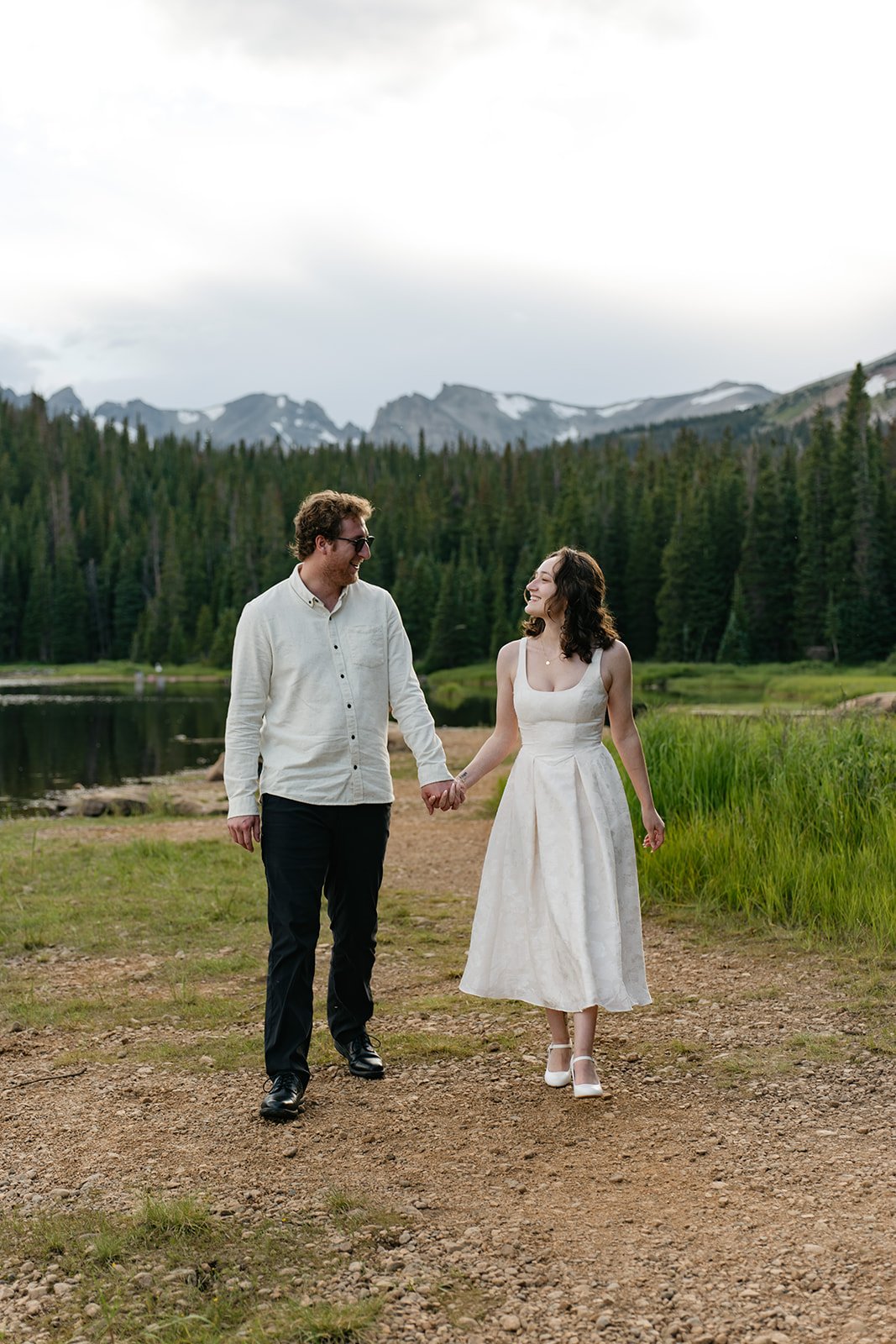 a couple holding hands by a lake at a Colorado Engagement Photo Location