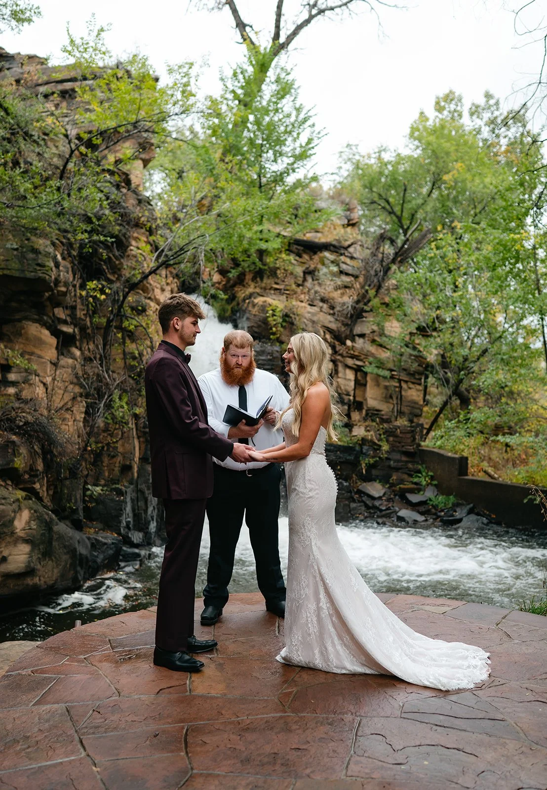 an elopement ceremony in front of a water fall at a Micro Wedding Venue in Colorado
