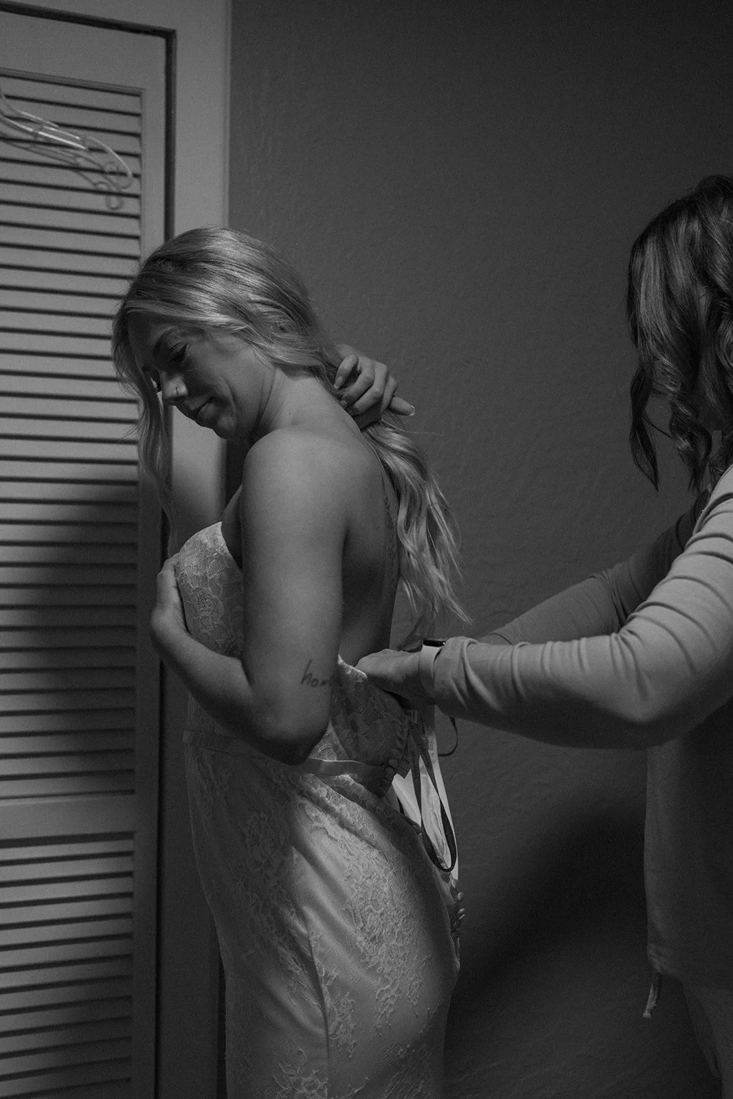 the bride's mom helping her with her dress