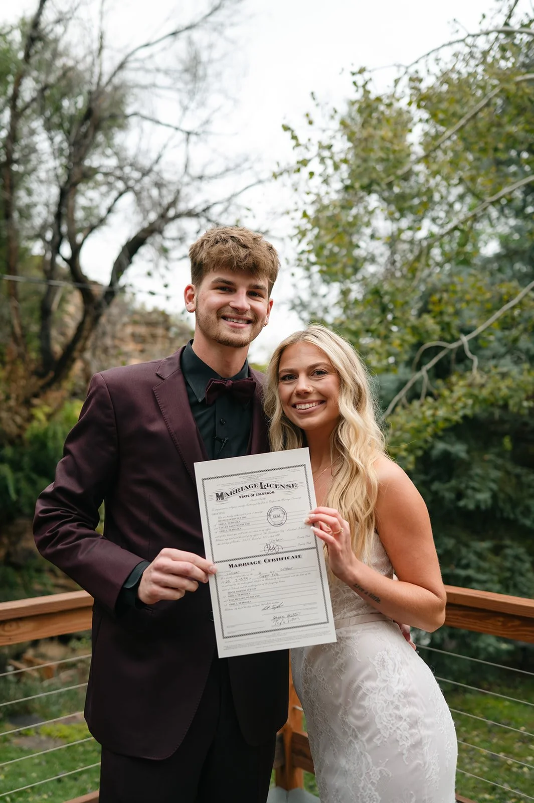 newlyweds holding up their marriage license