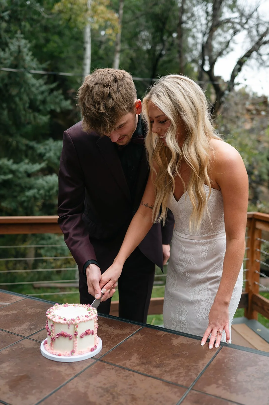 a bride and groom cutting their elopement cake at their micro wedding venue