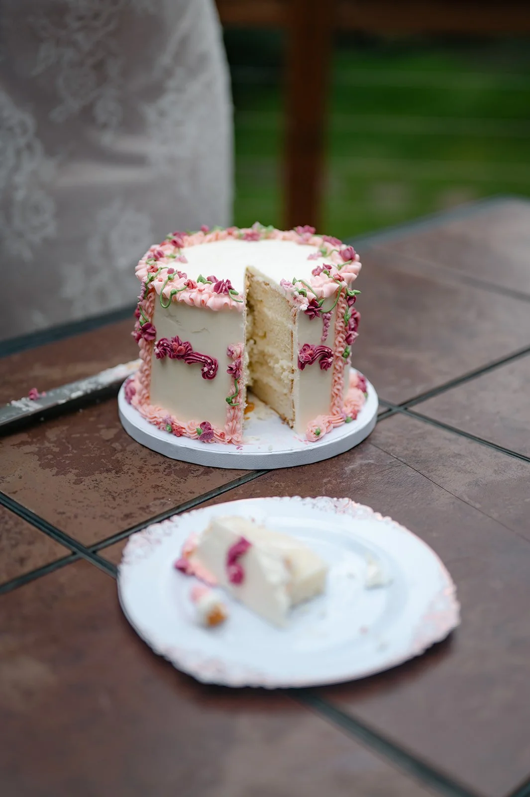 a white elopement cake with pink frosting 