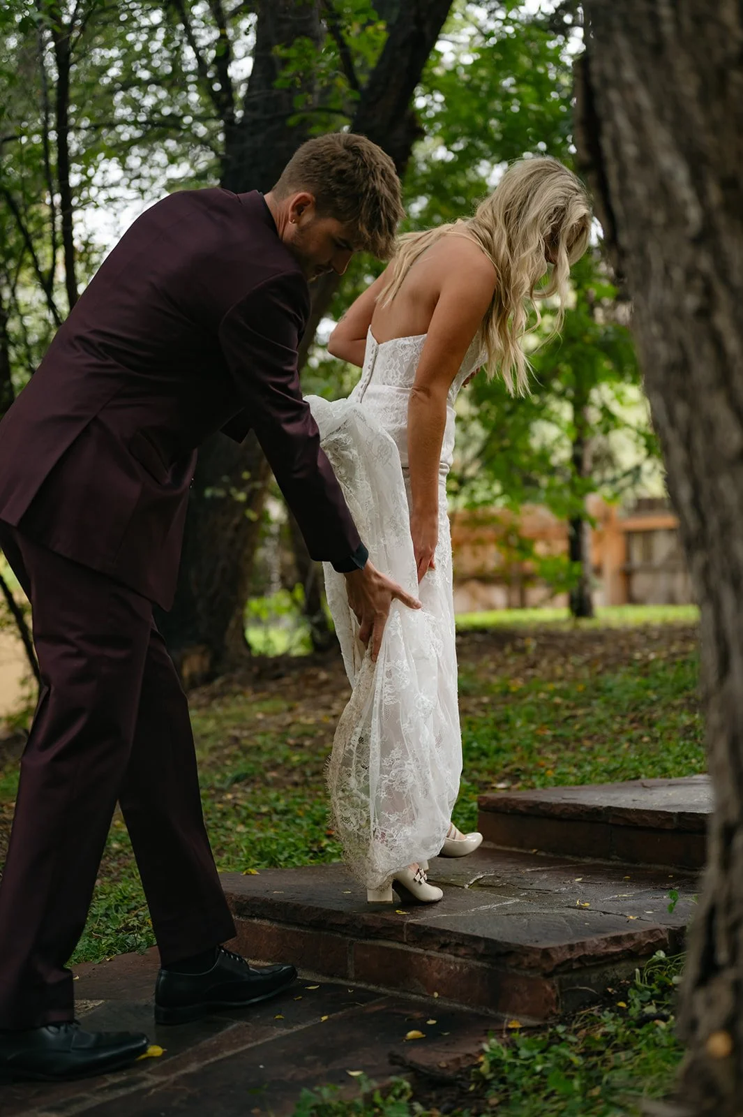 a groom helping a bride up some steps at a micro wedding venue in CO