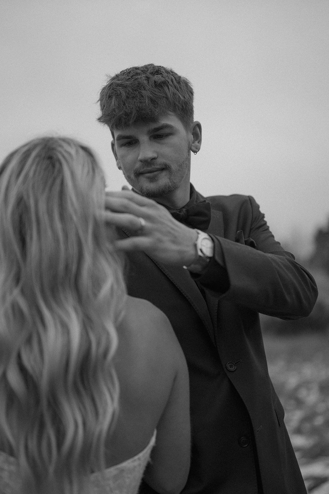 a groom brushing back a bride's hair for elopement portraits