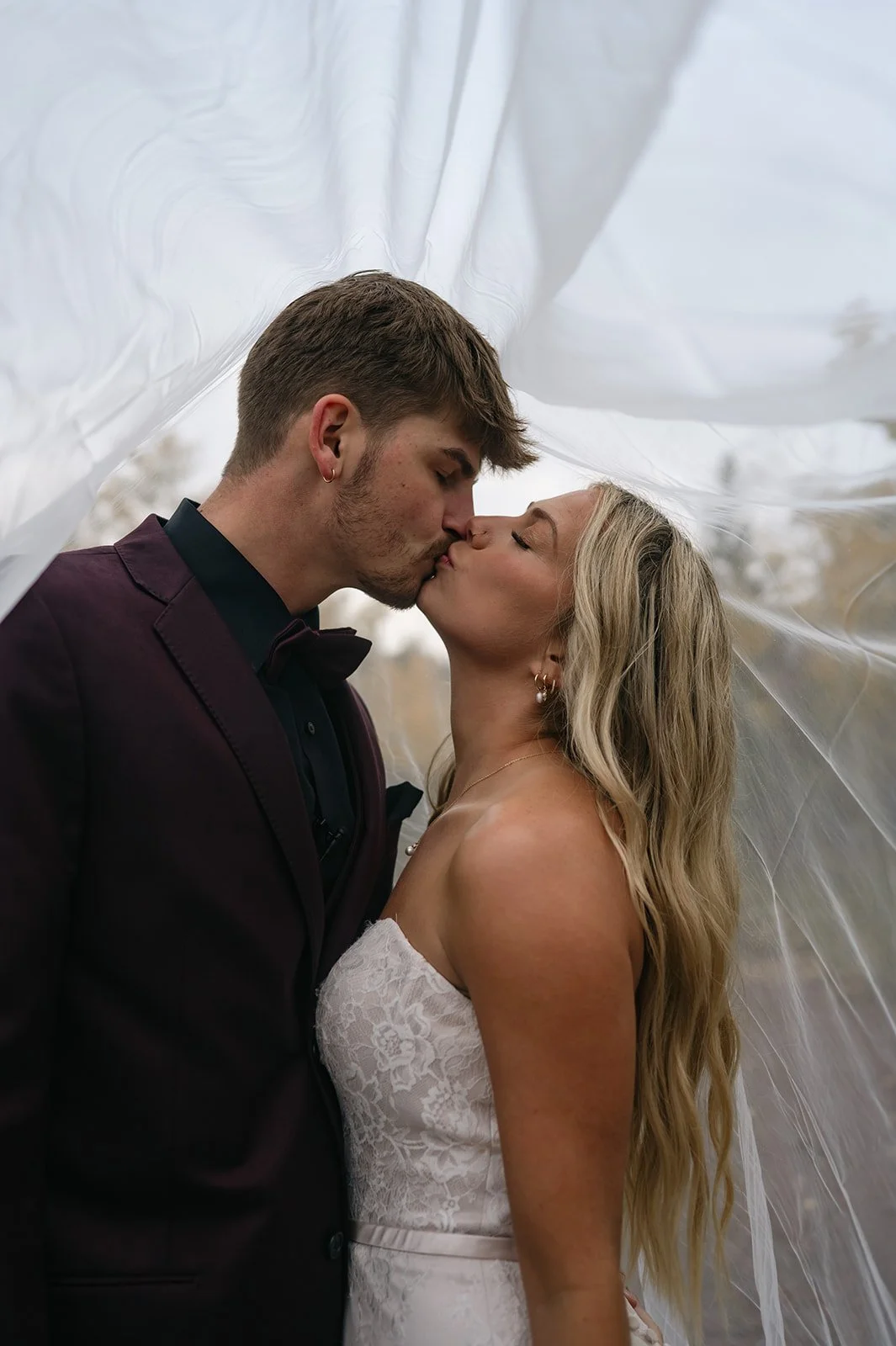 newly weds kissing under a veil during their Colorado elopement