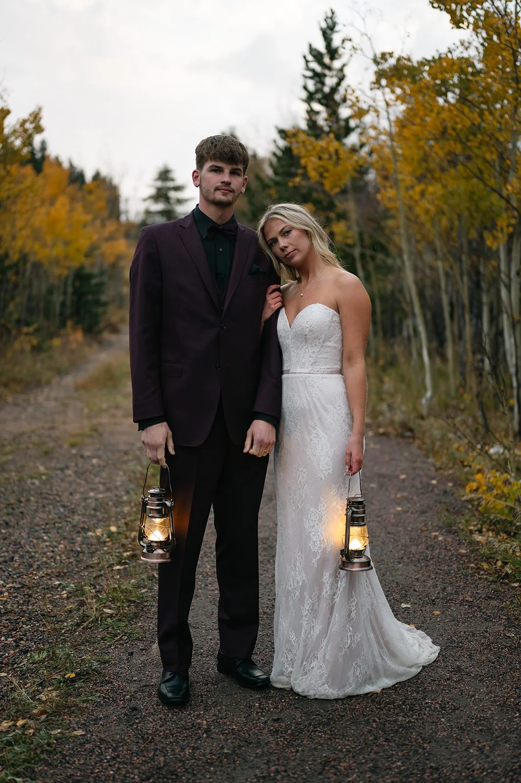 a bride and groom holding up lanterns during their elopement portraits