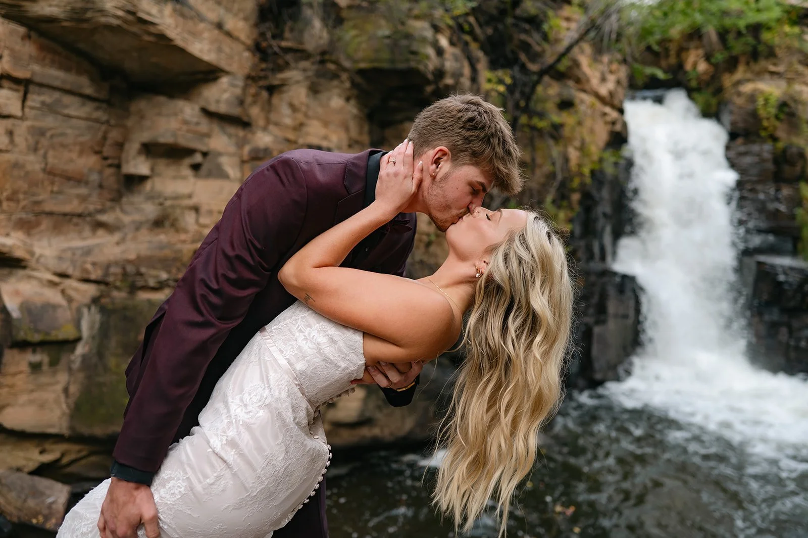 a man dipping a bride in front of a waterfall at a micro wedding venue