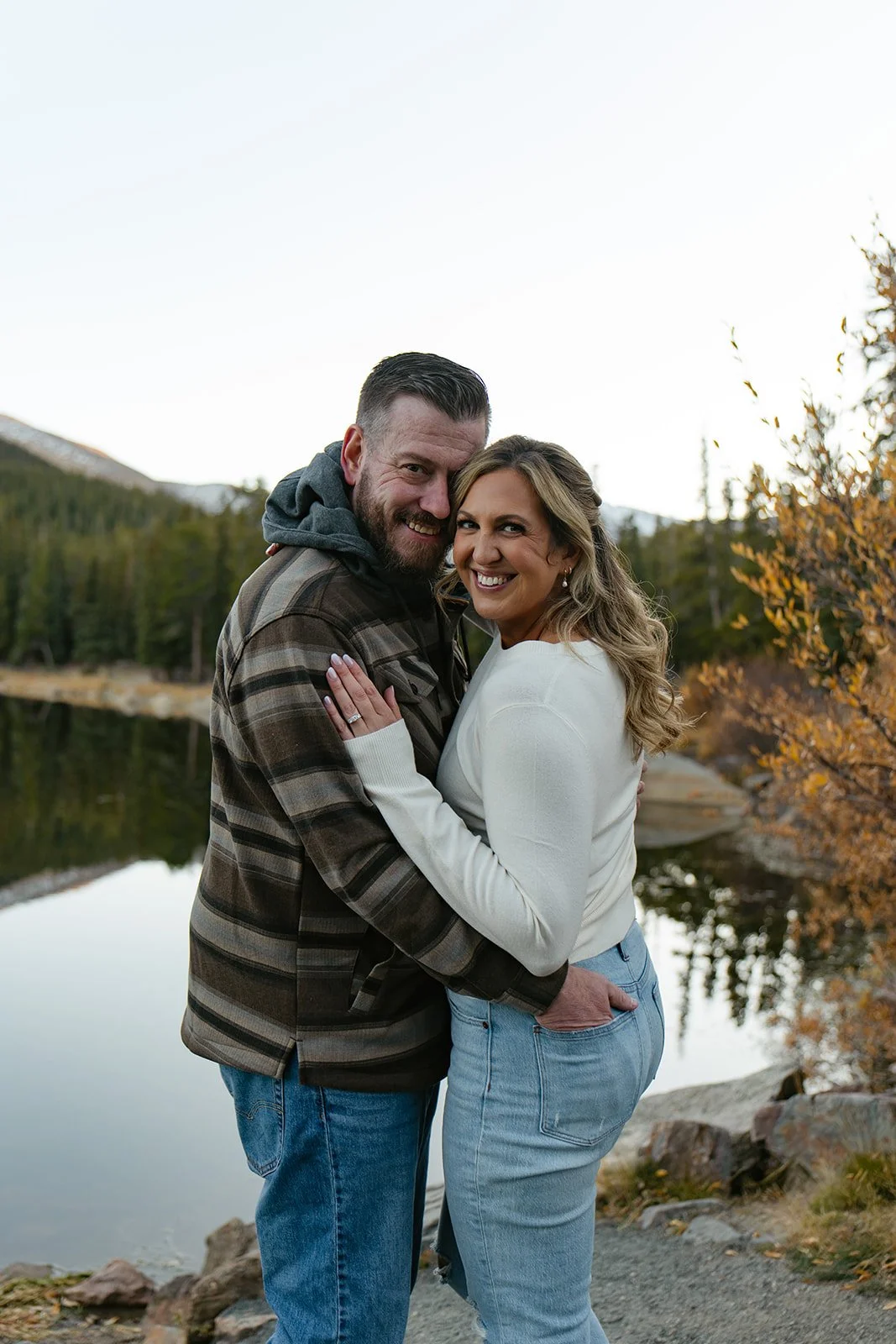 a couple smiling in front of the reflection on echo lake