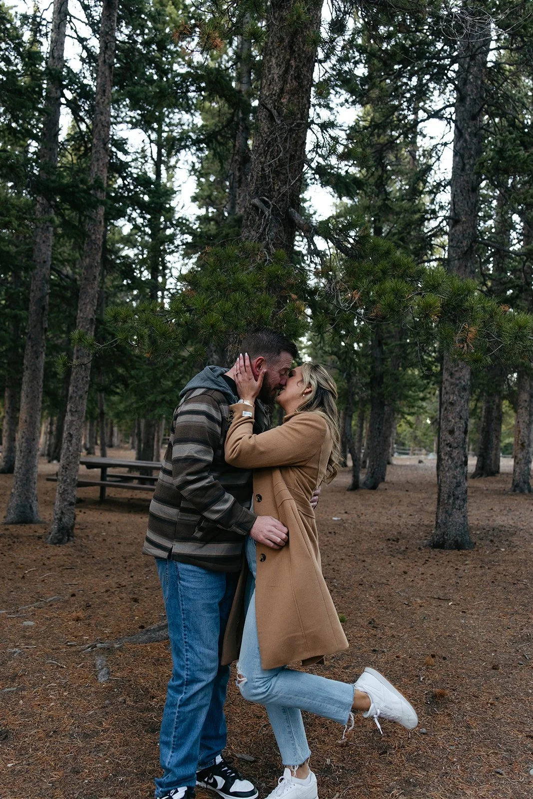 a couple in the wooded area of echo lake for engagement photos in Colorado
