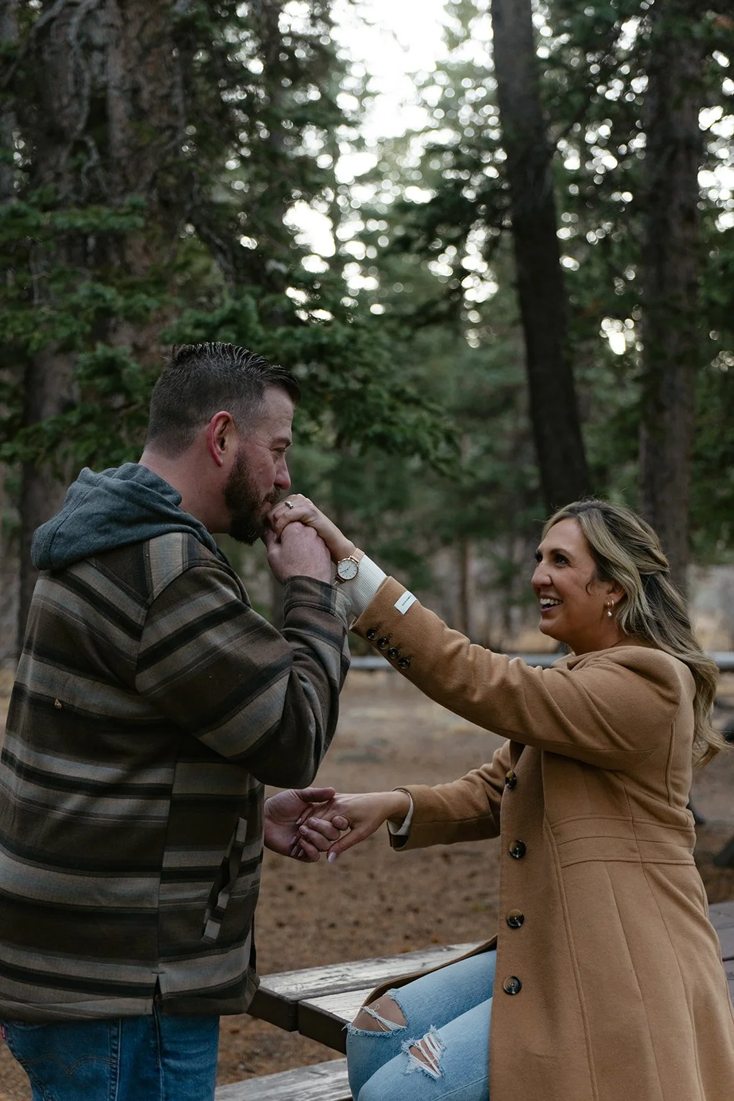 a man kissing a woman's hand during their engagement photos