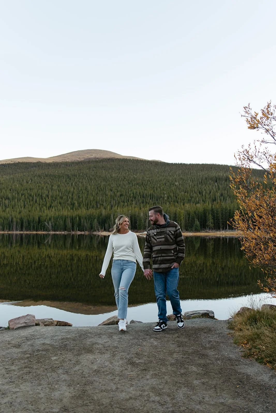 a couple holding hands in front of echo lake for their engagement photos