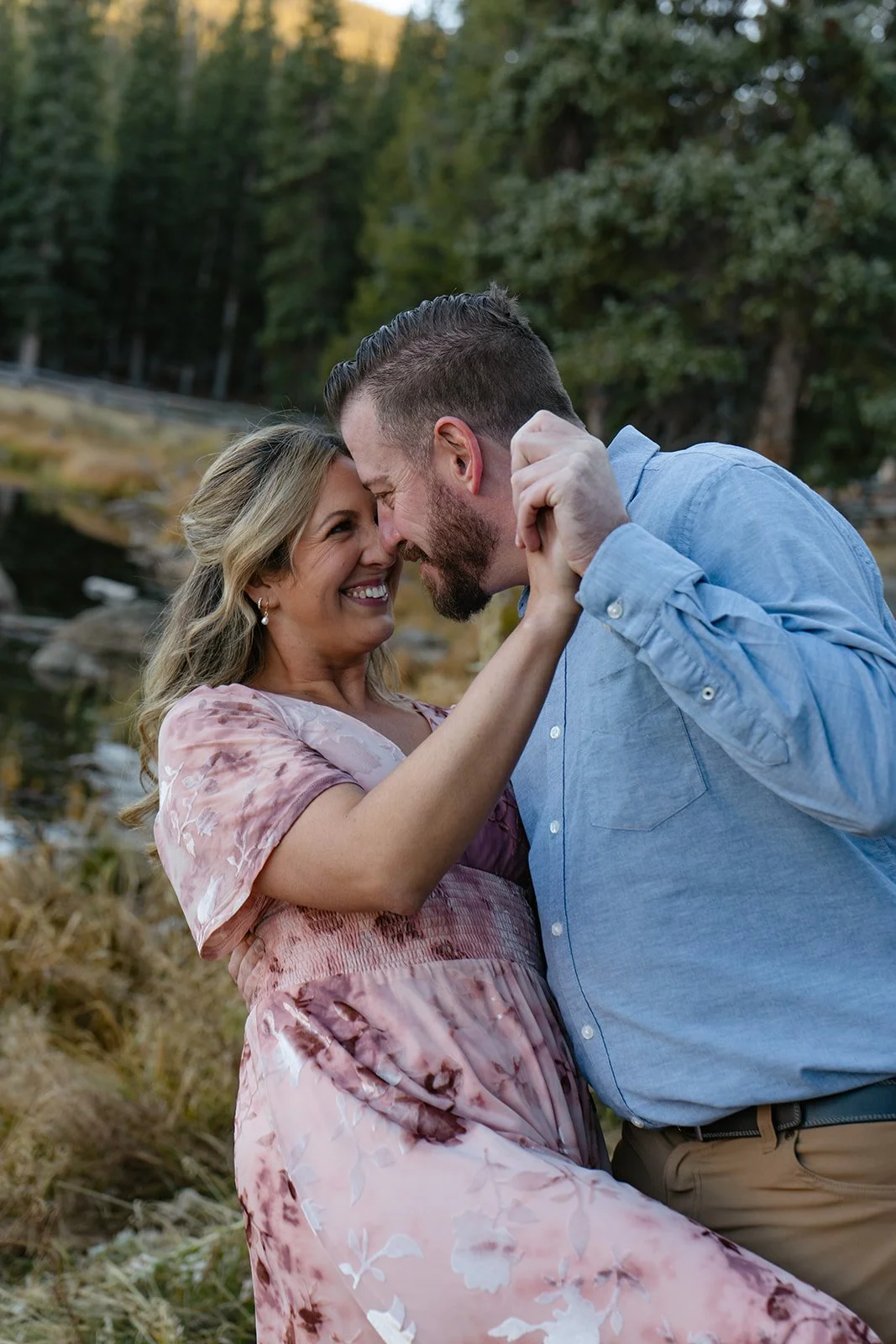 a man dipping a woman during their lake engagement photos in CO