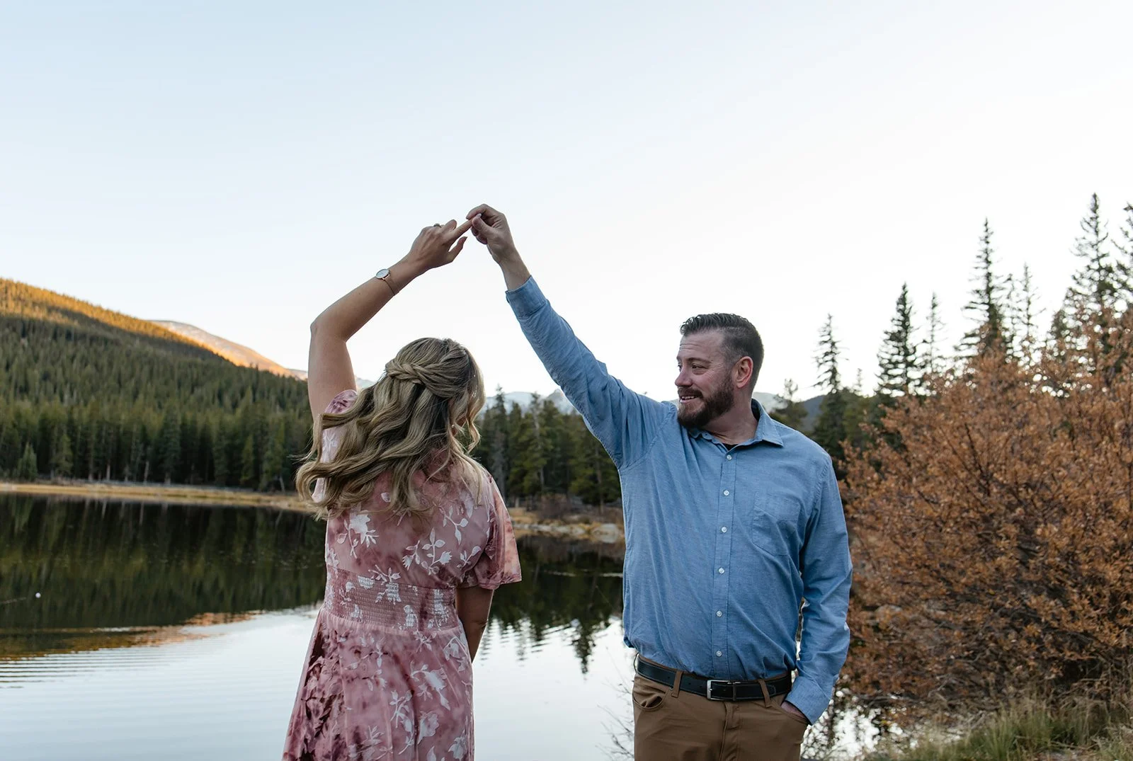a couple dancing in front of a reflective lake in CO