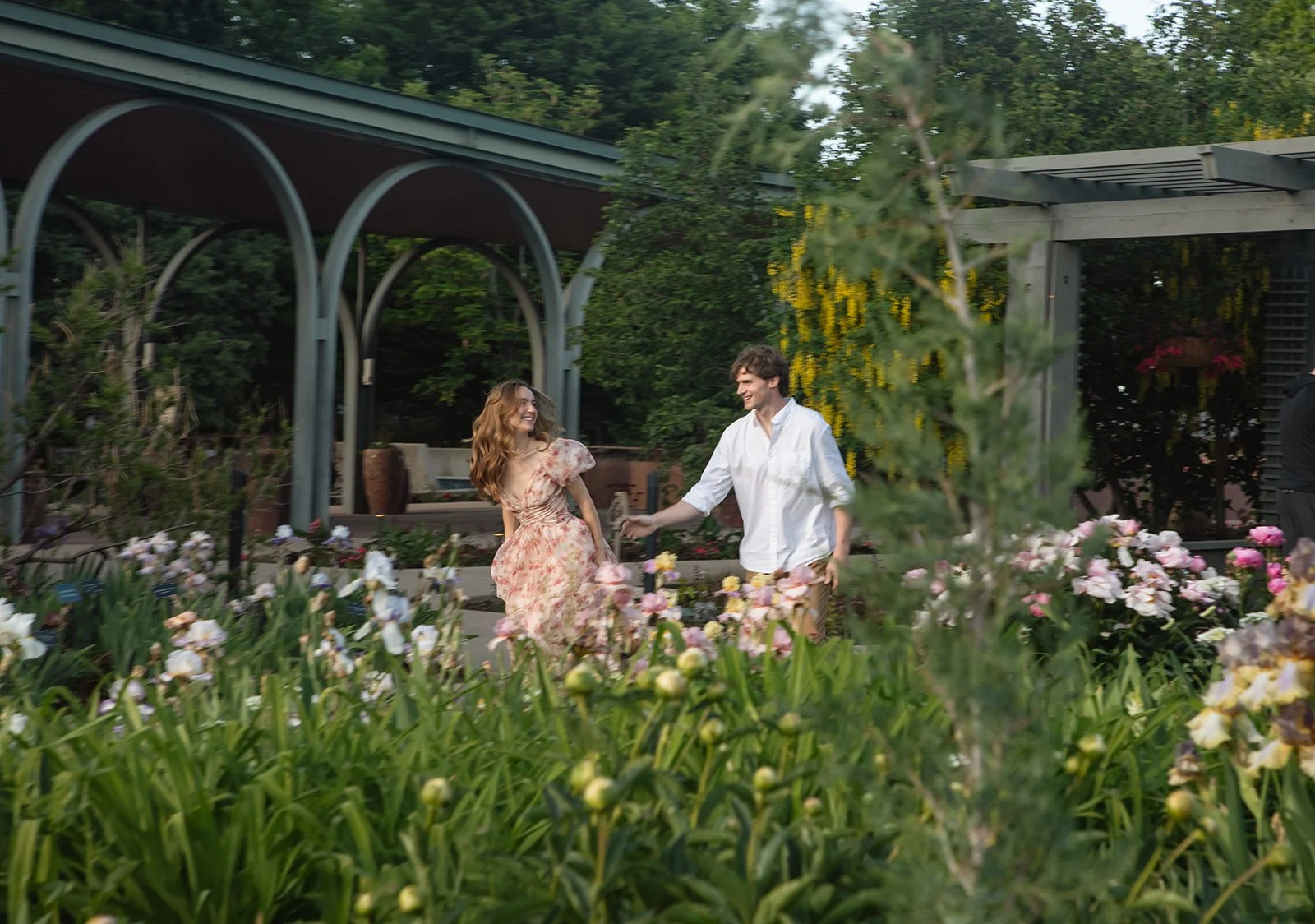 a couple running through a garden wearing the perfect Engagement Photo Outfits