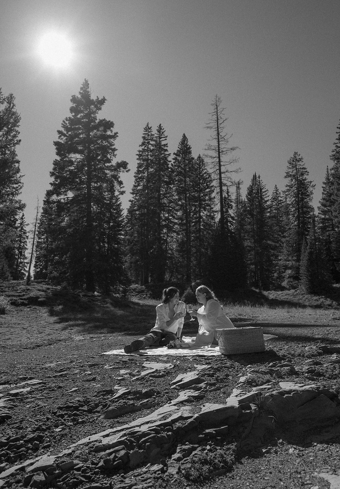 Black and white photo of couple having a picnic in the mountains during their Crested Butte elopement, showcasing documentary style elopement photography and intimate Colorado mountain moments.